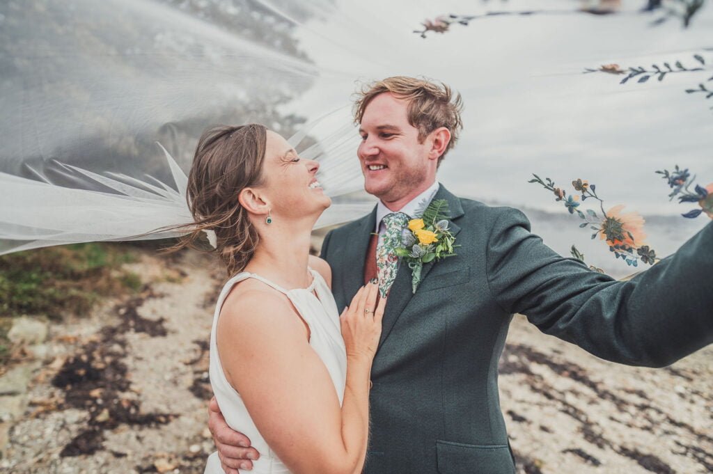 Bride and Groom on the beach feeling comfortable in front of the camera on their wedding day