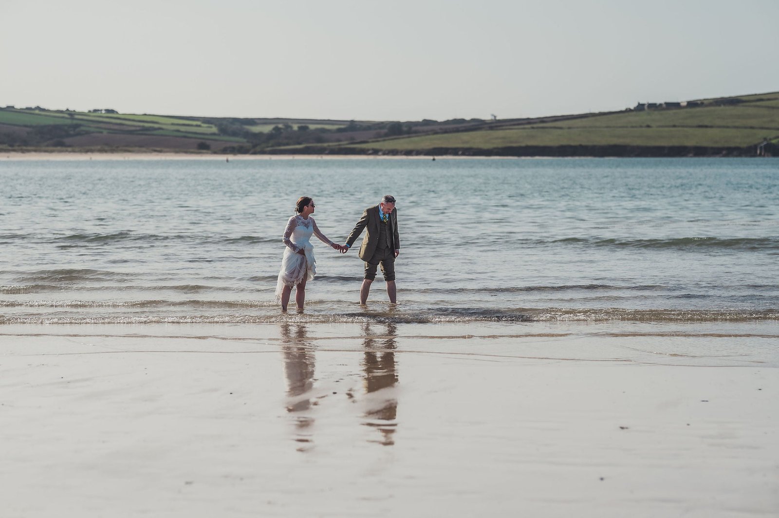 Bride and Groom paddling in the sea