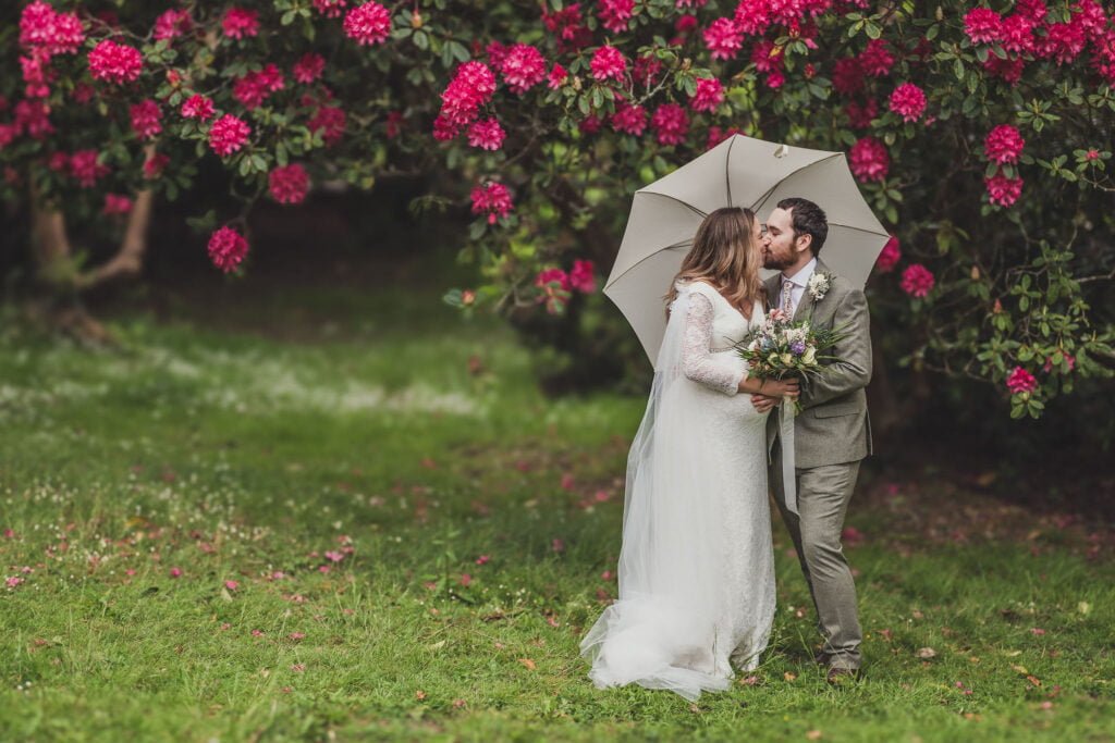 Bride and Groom under a white umbrella