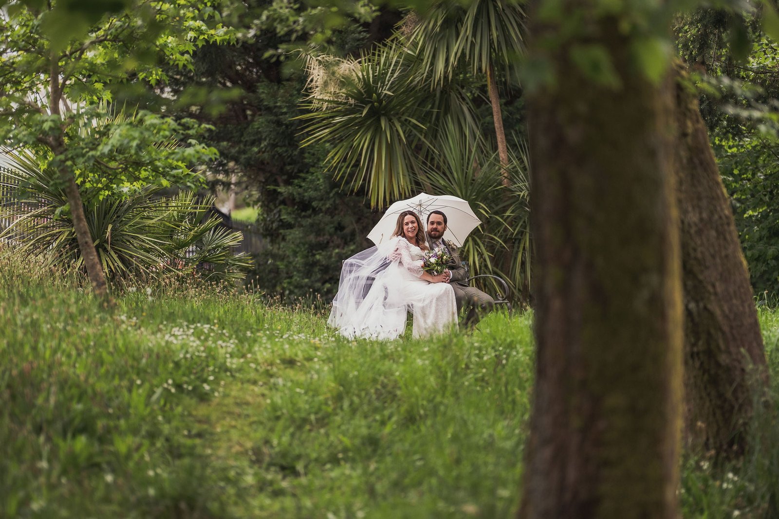 Bride and Groom in a garden with white umbrella