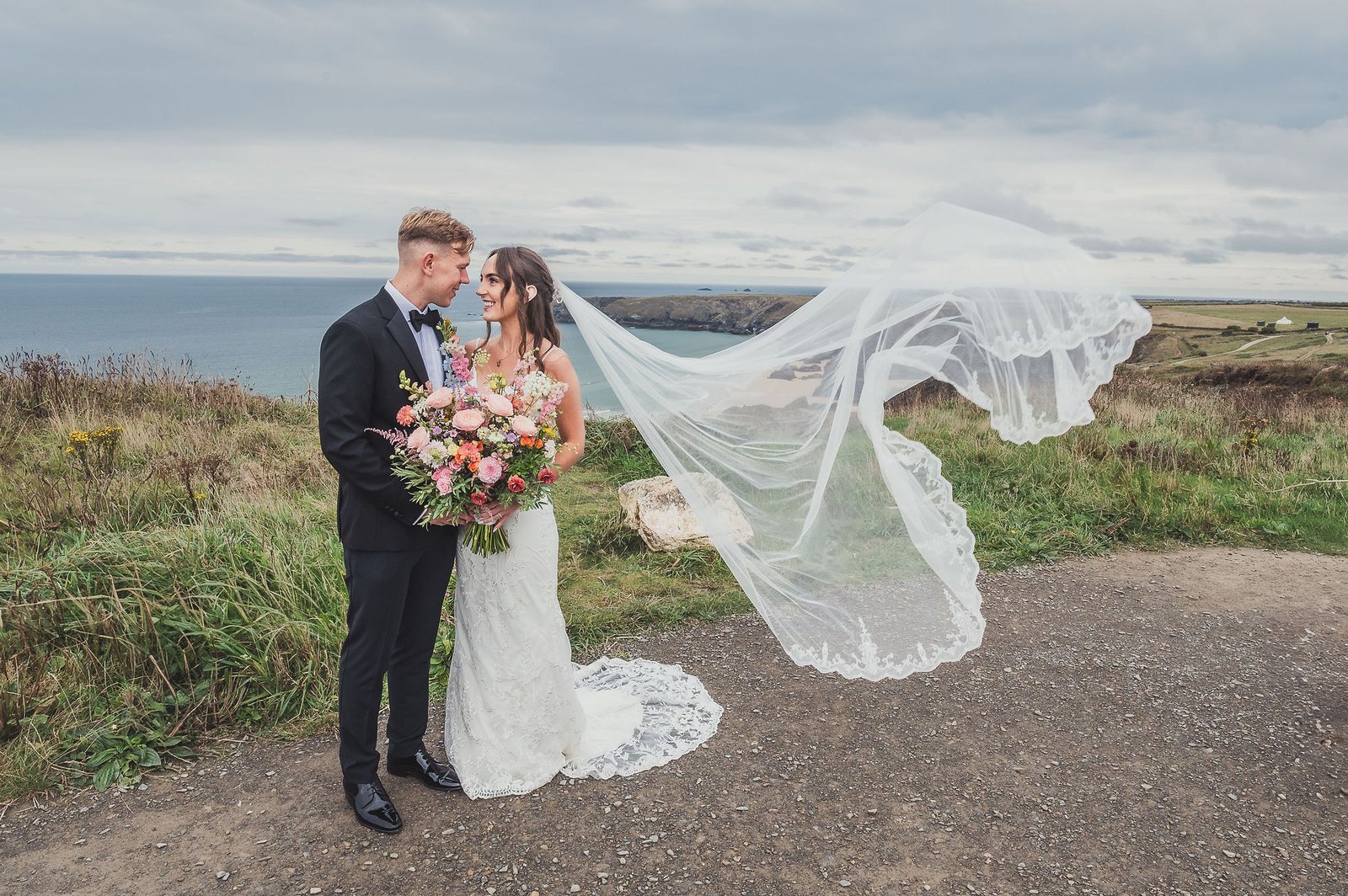 Bride and Groom by the sea with billowing veil