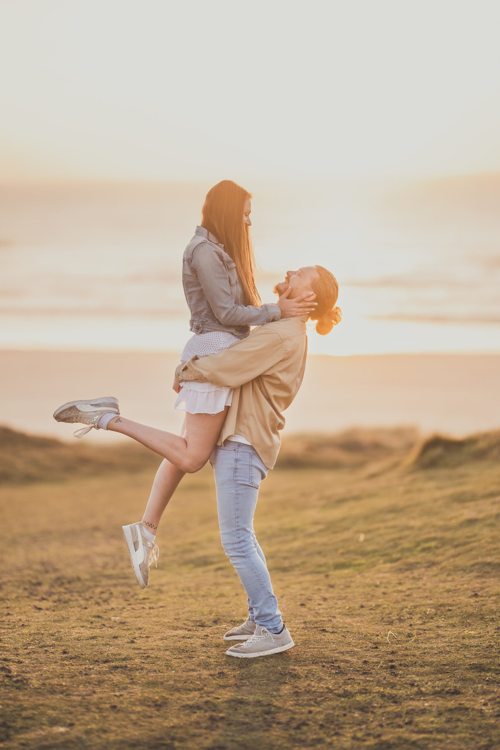 A couple embracing on a sunset pre-wedding shoot at Perranporth